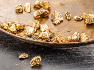 Gold nuggets on brass plate top view. Imitation of gold nuggets.