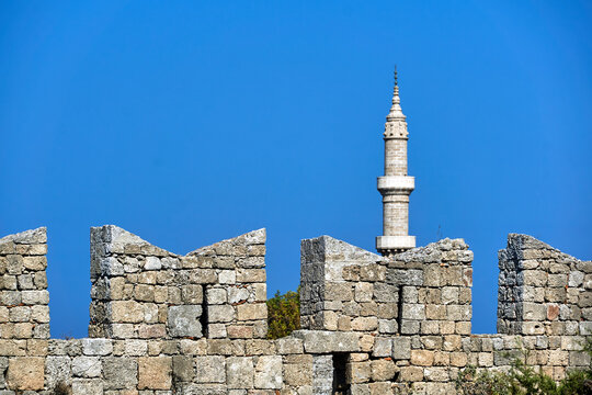 urkish minaret behind the medieval, stone defensive wall in Rhodes