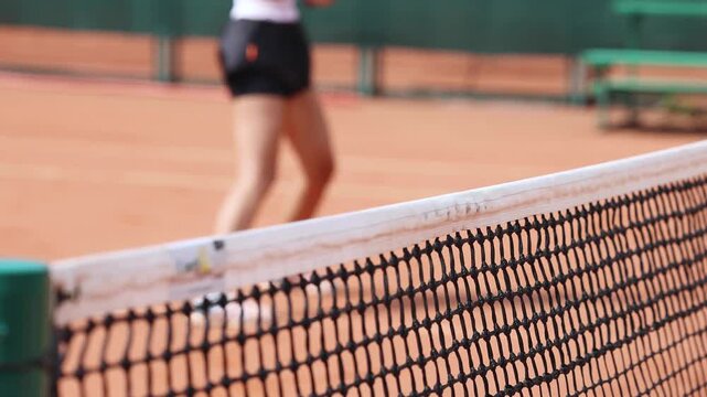 Tennis tournament championship on outdoor clay court with net, professional athletes play in motion with rackets serve tennis ball during tennis match game, tennis training in a sunny day on a stadium