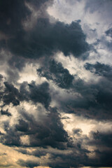 Dramatic sky with thick dark clouds before a storm. Daylight breaks through the dark thunderclouds. Overcast weather, natural background