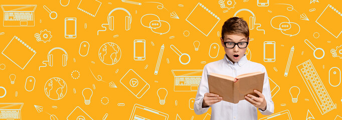 A child, filled with surprise, is engrossed in reading a book. The bright yellow background...