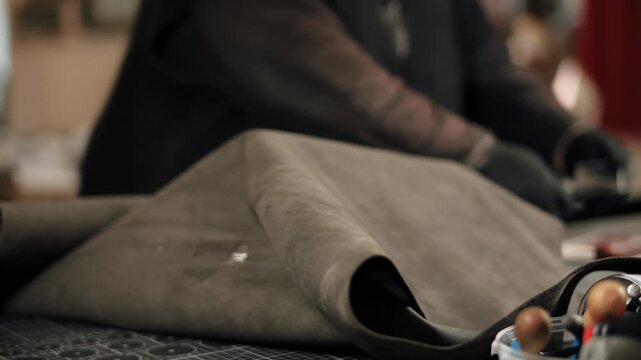 Leather craftsman cutting material on workbench