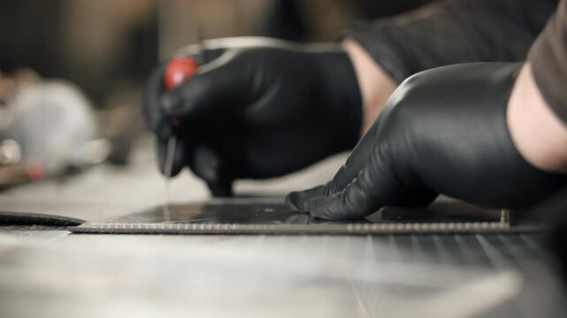 Craftsman marking leather pattern with awl tool