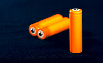 Three Orange AA batteries. Electricity charging. Battery for toys, electronics and equipment. Backup power supply.