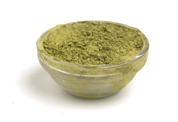 Glass bowl with matcha powder on a white background