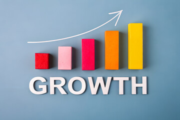 Business growth concept with colorful bar chart blocks on blue background