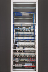 The reverse side of the electrical panel. Under copper insulated electrical wires to modules mounted on metal di-rack. 