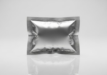 A shiny silver foil packet with a textured edge, isolated on a reflective white background