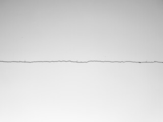 A crack in the plaster, a cracked white wall. A whitewashed wall, a damaged ceiling. A cracked white concrete wall.