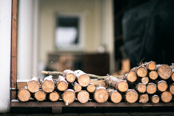 Freshly cut firewood stacked outside in the snow ready for a cozy fire during wintertime.