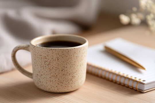 A coffee cup with a pen on a table