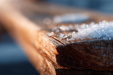A wooden bench with snow on it