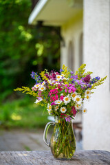 Beautiful bouquet of wild summer flowers in glass vase 