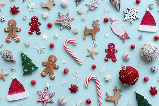 Festive Christmas decorations arranged on a blue background including gingerbread men and candy canes perfect for holiday-themed designs