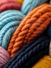 Close-up of a pile of colorful yarn. the yarn is made up of different shades of blue, pink, orange, yellow, and black.
