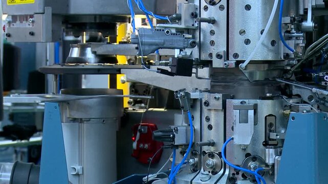 High-speed industrial circular knitting machine weaves textile threads with precision. Complex mechanical parts show modern automated production and efficiency in textile manufacturing.