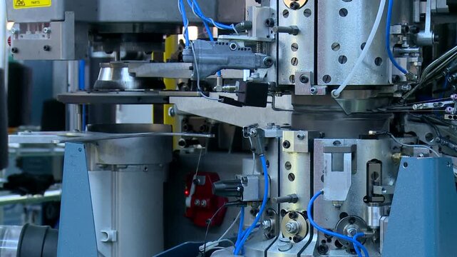 High-speed industrial circular knitting machine weaves textile threads with precision. Complex mechanical parts show modern automated production and efficiency in textile manufacturing.