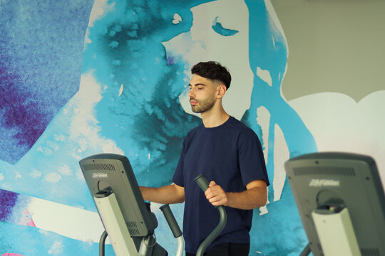 Man on an Elliptical Bike In a Gym - Powered by Adobe