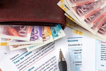  United Kingdom tax settlement. Tax forms. UK money wallet. Financial business concept. Filling out a form. Close up