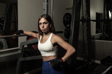 Athletic woman in gym, taking a break after weight training, fitness lifestyle