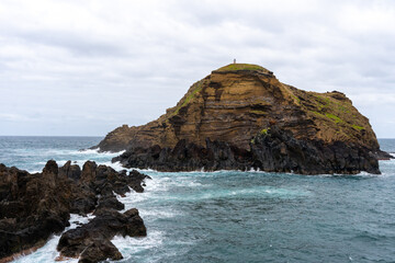 Obraz premium Waves crashing against black rocks in Porto Moniz in Madeira, Portugal