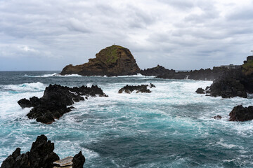 Fototapeta premium Waves crashing against black rocks in Porto Moniz in Madeira, Portugal