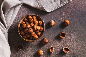 High-calorie peeled hazelnuts in a bowl on the table top view