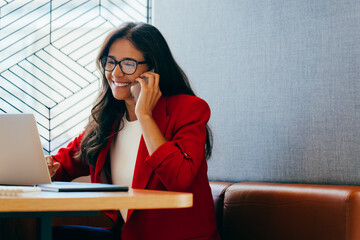 Businesswoman in red jacket working and talking on phone