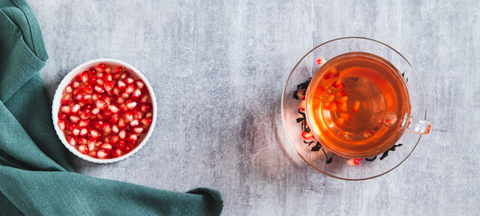 Herbal green infused pomegranate tea in a cup on the table top view web banner