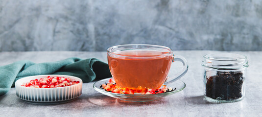 Herbal green infused pomegranate tea in a cup on the table web banner