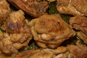 Pieces of chicken meat are fried in a frying pan, exuding flavor and mouth-watering appearance. Delicious chicken pieces are fried in a frying pan until golden brown.