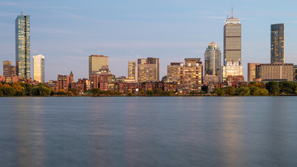 The skyline of Boston in Massachusetts at night as seen from Memorial Driver Road in Cambridge, MA, USA with the famous Charles river in between the two cities.