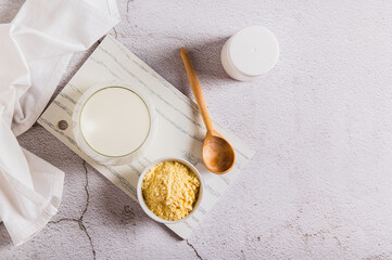 Colostrum powder in a bowl and a drink in a glass on a table top view