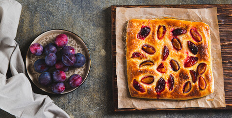 Sweet homemade focaccia with berries on paper on the table top view web banner