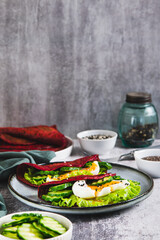 Beet chia tacos with egg, cucumber and lettuce on a plate on the table vertical view