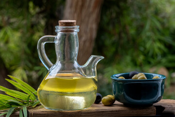 Aceitera y bol con aceitunas con fondo natural