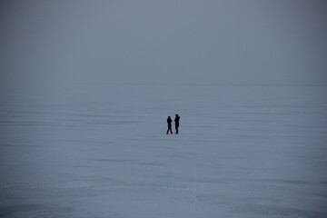 two silhouetted figures in snow silence