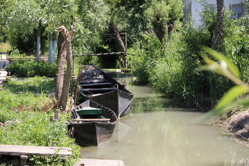 weathered boats moored in murky brown waters
