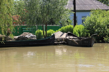 rustic waterfront scene where weathered black boats 