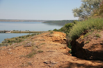 red earth pathway winding along a waterside landscape