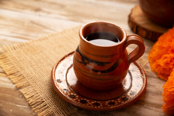 Cafe de Olla, traditional black Mexican coffee, spiced with cinnamon and piloncillo, prepared in a pot and served in a handmade clay cup called a jarrito.