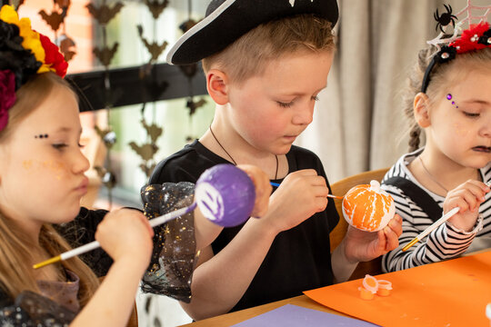 Kids making Halloween crafts in costume. Halloween craft workshop.  - Powered by Adobe