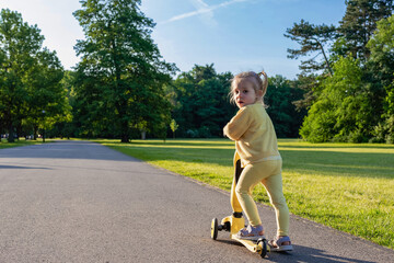 Scooter and kid. Toddler outdoor riding. Fun yellow play childhood freedom.