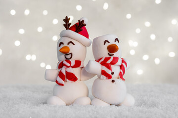 A marshmallow snowman with a red scarf and a carrot nose