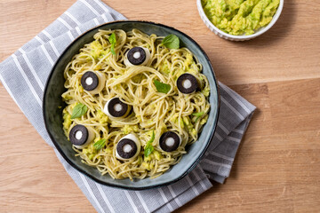 A bowl of pasta with olives and sauce