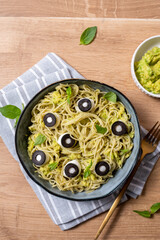A bowl of pasta with olives and sauce
