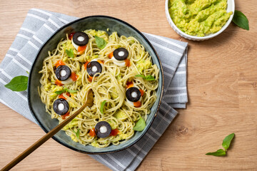 A bowl of pasta with olives and sauce