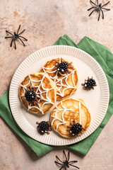 A plate of spider web pancakes with blackberries on top. Halloween food