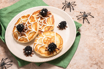 A plate of spider web pancakes with blackberries on top. Halloween food