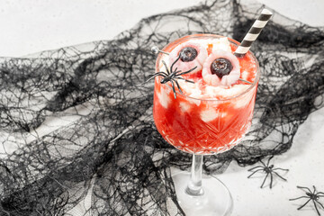 A glass of strawberry tea smoothie with whipped cream for Halloween